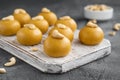 Indian sweets Besan Laddu or Laddoo on a wooden board on a concrete bacground. Roasted chickpea flour with ghee and sugar. Royalty Free Stock Photo