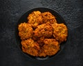 Indian takeaway food, spicy onion bhajis on black plate Royalty Free Stock Photo