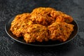 Indian takeaway food, spicy onion bhajis on black plate Royalty Free Stock Photo