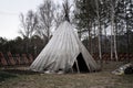 Traditional Indian wigwam in the forest among the trees.Traditional Indian wigwam in the forest among the trees. Indian tents at a Royalty Free Stock Photo