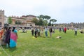 Indian tourists in grounds outside near Tower of Pisa in group taking photos