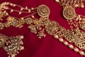 Indian traditional gold Indian wedding women`s jewelry on red saree background. Close-up. Still-life Royalty Free Stock Photo