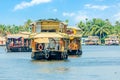 Indian traditional houseboats floating on Pamba river, with palms at the coastline, Alappuzha, Kerala, South India