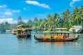 Indian traditional houseboats floating on Pamba river, with palms at the coastline, Alappuzha, Kerala, South India