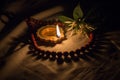 Indian traditional oil lamp made of clay with glowing flame, jasmine flower & clay beads necklace kept on cloth background during Royalty Free Stock Photo