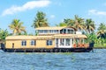 Indian traditional tourist houseboats floating on Pamba river, with palms at the coastline, Alappuzha, Kerala, South India Royalty Free Stock Photo