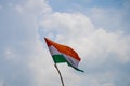Indian tricolor flag mounted on a makeshift stick shot against a cloudy sky on a patriotic republic independence day