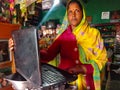 indian grocery store woman operating laptop computer system at shop counter in india January 2020