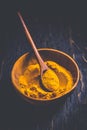 Indian turmeric powder, curcuma spice in small bowl with spoon, Haldi powder