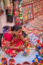 An Indian Unidentified middle-aged woman paints on colourful handicraft items for sale in Kolkata in handicrafts trade fair. It is