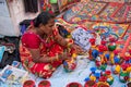 An Indian Unidentified middle-aged woman paints on colourful handicraft items for sale in Kolkata in handicrafts trade fair. It is