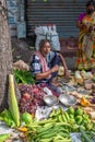 An Indian unidentified vegetable seller selling vegetables at the street next to the road at the local market in Kolkata, India on