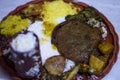 Indian vegeterian food plate that includes several curries with yellow and white rice