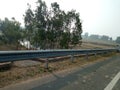 INDIAN VILLAGE ROAD ,BRIDGE AND PLANT IMAGE WITH ROAD BARICATE, BOTH SIDE TREES AND BEAUTIFUL SUNSHINE