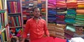 an indian village clothes shopkeeper standing inside the store in India