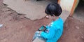 An indian village cute little baby girl using smart phone at courtyard