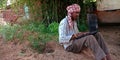 An indian village farmer operating computer system seating at land Royalty Free Stock Photo