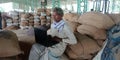 An indian village farmer operating laptop computer system seating upon wheat sacks at farmers market Royalty Free Stock Photo