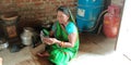 An indian village farmer woman operating smart phone seating at home Royalty Free Stock Photo