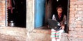 Indian village farmers girl operating laptop computer system seating at corridor