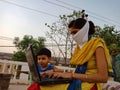 An indian village female teaching little kids about computer technology wearing face mask in india May 2020