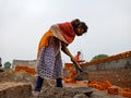 an indian village female worker mixing raw material at construction site in India December 2019