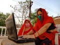 An indian village lady teaching matured woman about computer technology wearing face mask in india May 2020