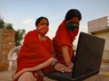 An indian village lady teaching matured woman about computer technology wearing face mask in india May 2020