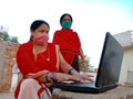 An indian village lady to the poor woman about computer technology wearing face mask in india May 2020
