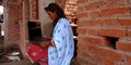 An Indian village girl watching laptop computer while seating at corridor