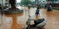 indian village kids riding cycle during flood on road in India aug 2019 Royalty Free Stock Photo