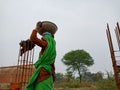 an indian village lady labour transporting building materials at construction site in India December 2019
