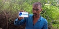 An indian village man displayed PayPal logo on mobile phone screen