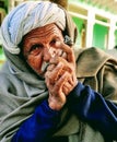 Indian village old man smoking Ganja Marihuana with chillum/hukkah in Rajasthan& x27;s traditional dress turban on head in winter