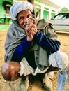 Indian village old man smoking Ganja Marihuana with chillum/hukkah in Rajasthan& x27;s traditional dress turban on head in winter