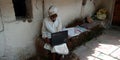 An indian village old man working at computer system