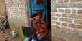 An indian village poor boy operating laptop system seating at corridor Royalty Free Stock Photo