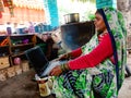 indian village poor woman operating laptop computer system at local food shop in india January 2020