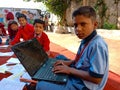 an indian village private school student holded laptop while studying at open area class in india January 2020