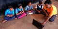 Indian village school students learning computer operating system from teacher at classroom