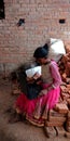 An indian village teen operating laptop while seating at brick wall Royalty Free Stock Photo