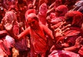 Indian Widows covered with colored powder and flower petals .