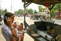 Indian woman with baby talking on her mobile phone at a roadside eatery place. Royalty Free Stock Photo