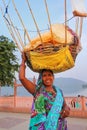 Indian woman with basket on her head selling snacks by Man Sagar Lake in Jaipur, India.