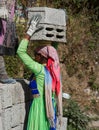 Indian woman carries two stone blocks on her head