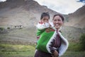 Indian woman carrying baby on her back in spiti valley