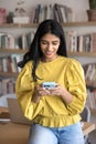 Indian woman chatting on smartphone in office or library Royalty Free Stock Photo