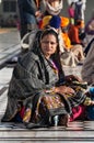 Indian woman with child sitting near the lake at Golden Temple. Amritsar. India Royalty Free Stock Photo