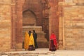 Indian woman in colorful dress standing in Qutub Minar complex,