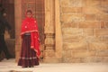 Indian woman in colorful dress standing in Qutub Minar complex,